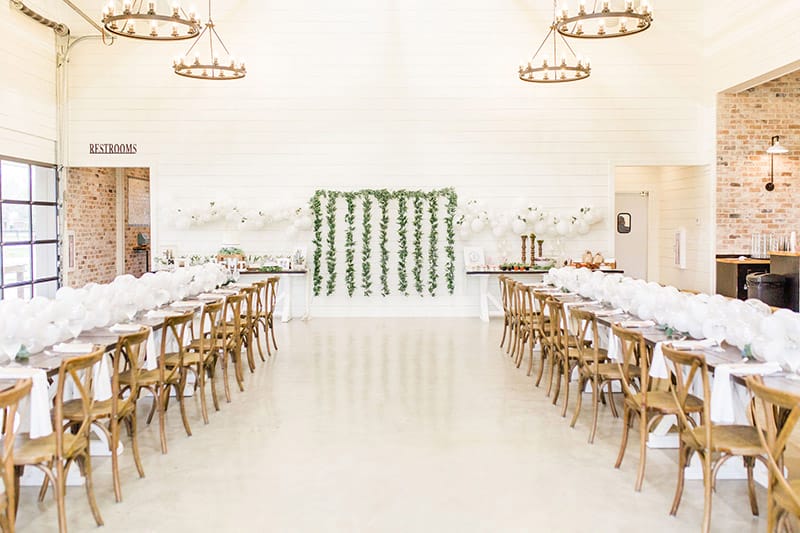 a beautiful chairs in a long table with succulent theme backdrop