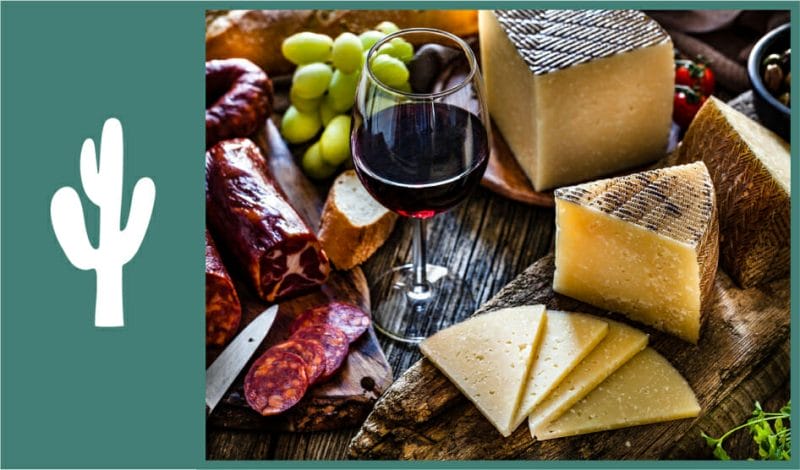 red wine paired with cheese and fruits on the table