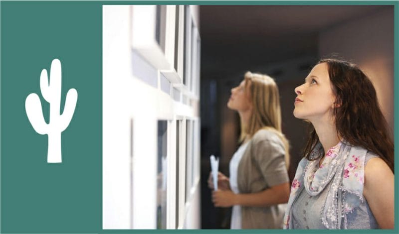 two woman looking at art galleries hanging on the wall